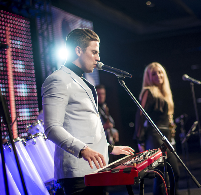 The live karaoke band host keeps the singers brave, the room loud and the show moving.